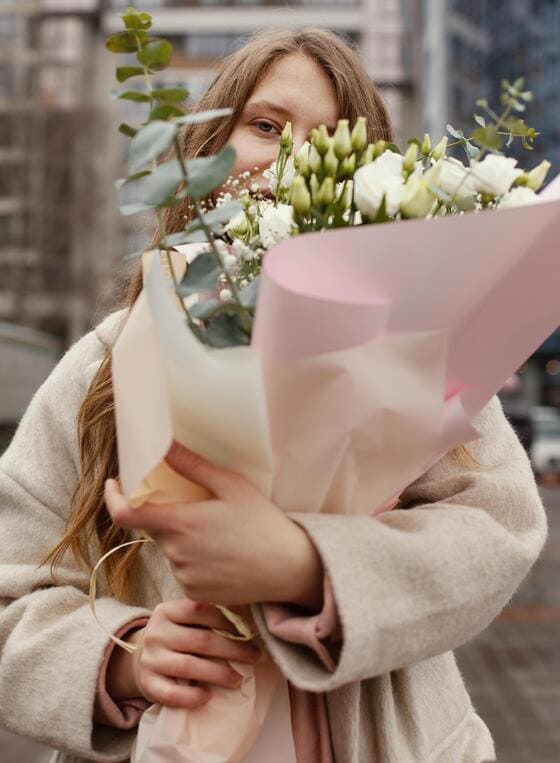Elegante vrouw die met een mooi boeket in Odijk naar huis loopt